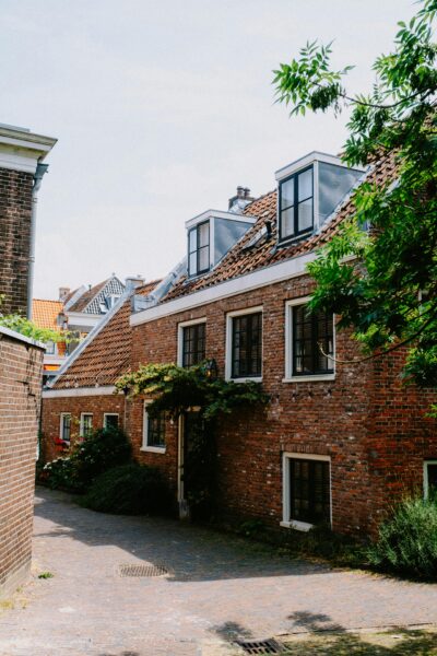 A picturesque view of classic red brick houses on a quaint street under a clear summer sky.