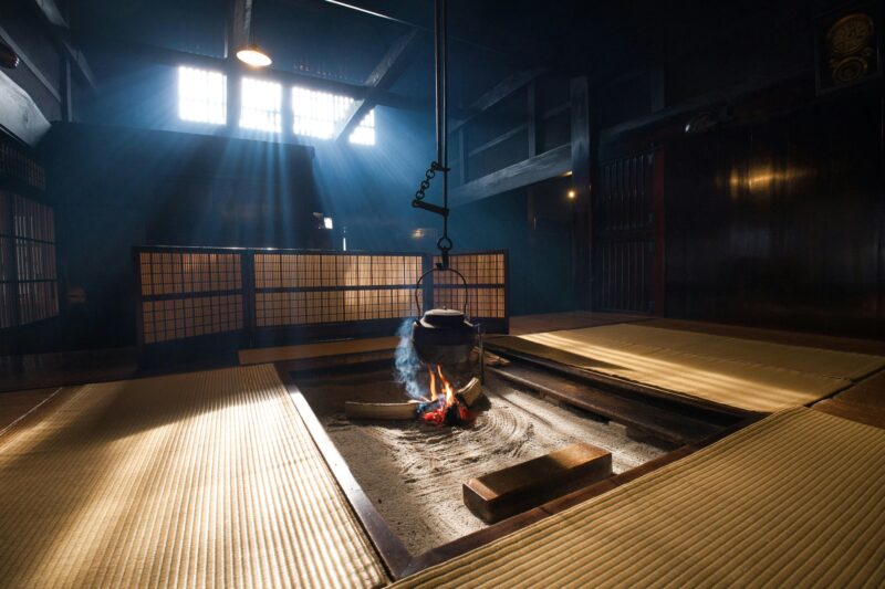A serene Japanese tatami room with sunlight streaming in and a traditional fire pit.