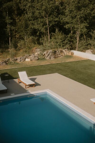 Peaceful outdoor pool area with sun loungers overlooking greenery in Omiš, Croatia.