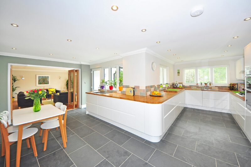 Spacious modern kitchen with elegant interiors featuring a dining table and luxurious design.