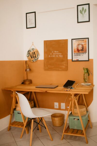 A minimalist home office featuring a wooden desk, chair, and wall art, creating a cozy atmosphere.