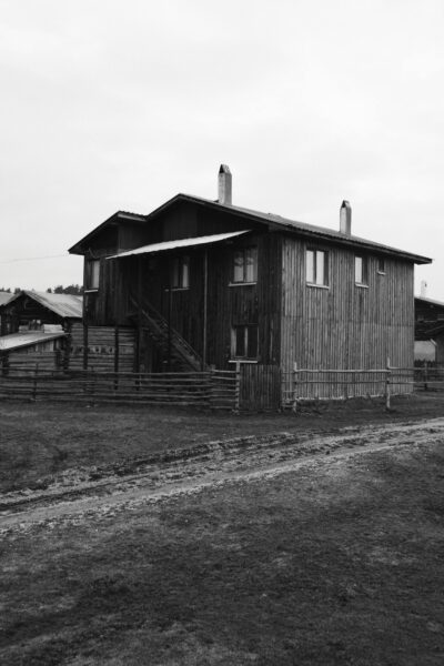 Captivating black and white image of a traditional wooden farmhouse in a rural setting.