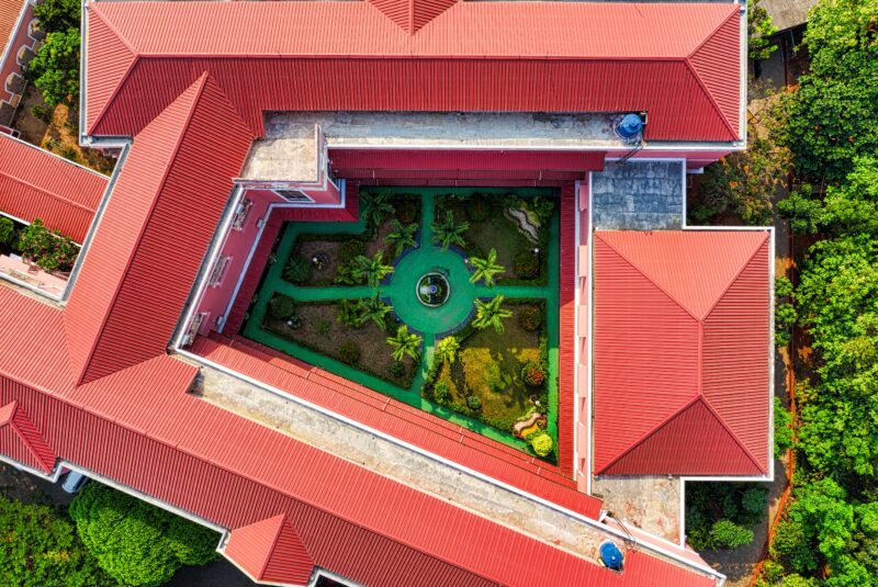 Aerial shot of a red roofed building with a lush green courtyard in Jakarta, Indonesia.
