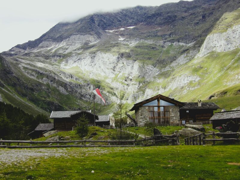 Charming rural farmhouse set against majestic Trentino-Alto Adige mountain landscape.