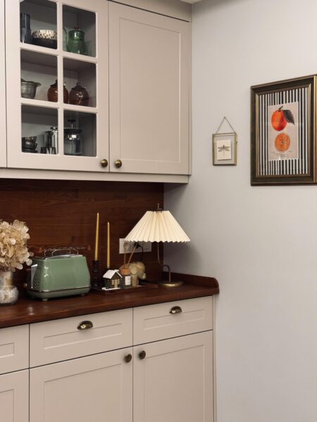 Charming vintage kitchen corner featuring a retro toaster, floral decor, and elegant lighting.