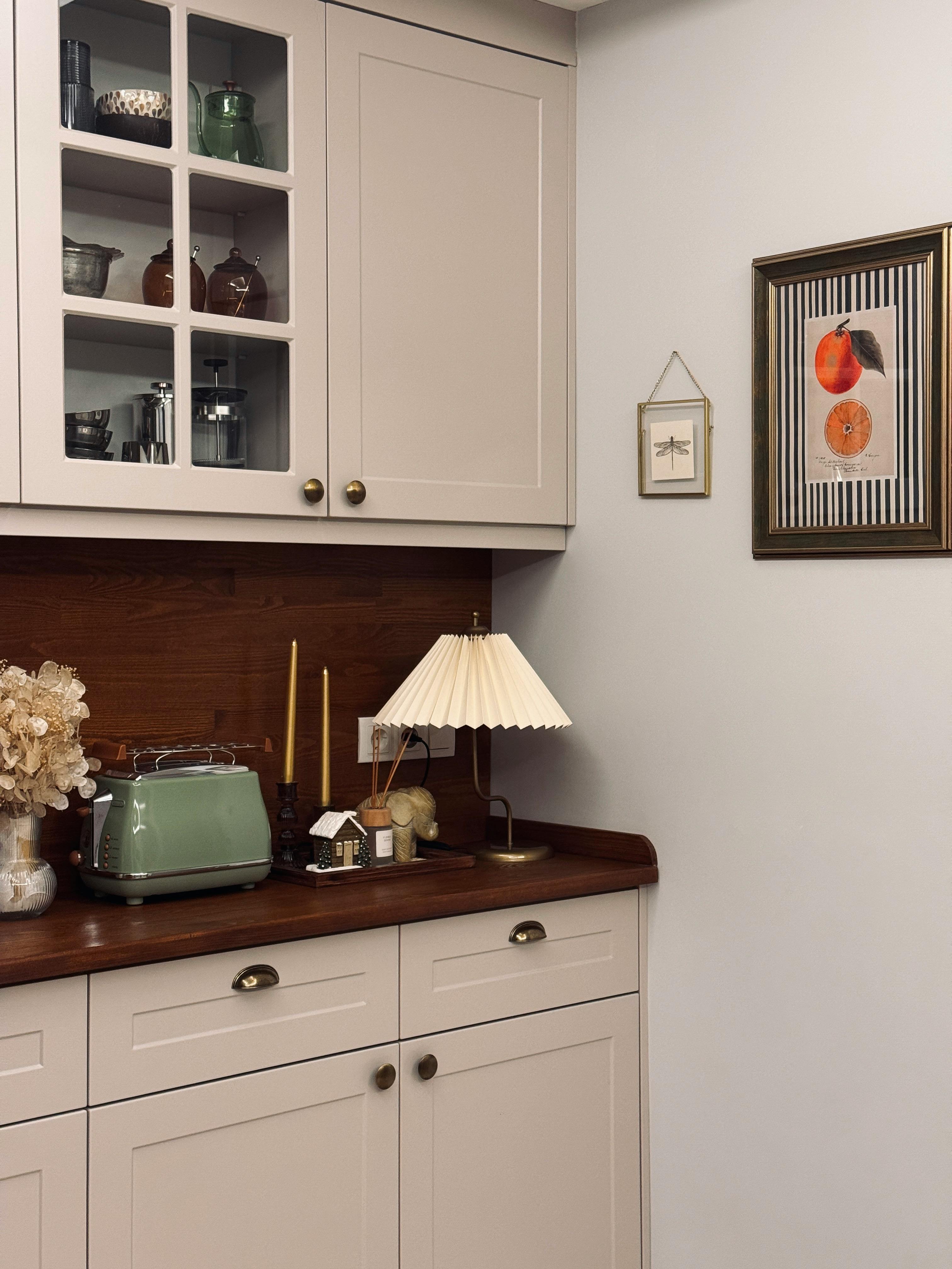 Charming vintage kitchen corner featuring a retro toaster, floral decor, and elegant lighting.