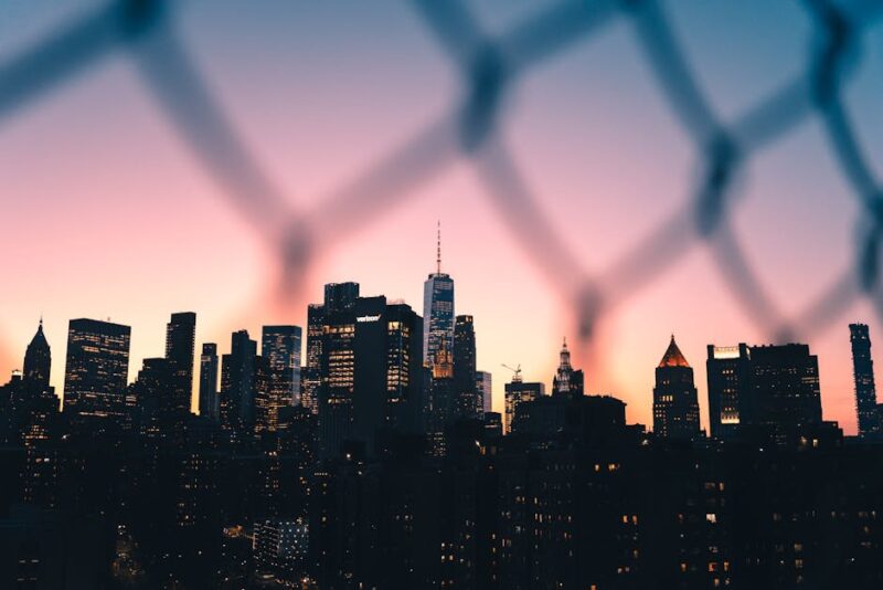 New York City skyline at sunset through fence