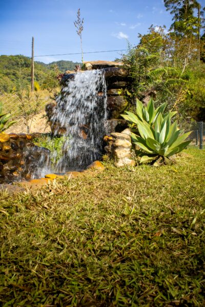 Beautiful outdoor garden waterfall in Gaspar, Santa Catarina, Brazil, surrounded by lush greenery.