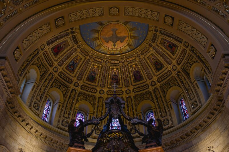 Intricate mosaic details inside a basilica dome, showcasing religious and architectural artistry.