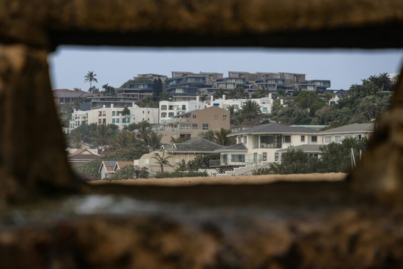Scenic coastal homes viewed through rustic frame