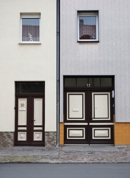 A photograph of two twin buildings, showing two doors numbered 10 and 12, on a table.
