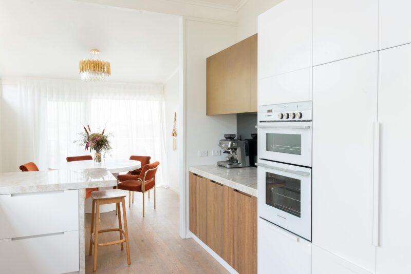 Bright kitchen interior with white cabinets and elegant decor, perfect for contemporary living.