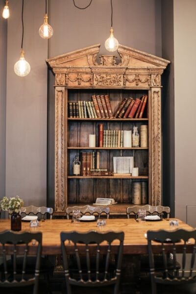 A cozy dining room with vintage bookshelf and warm lighting, perfect for a classic interior design setting.