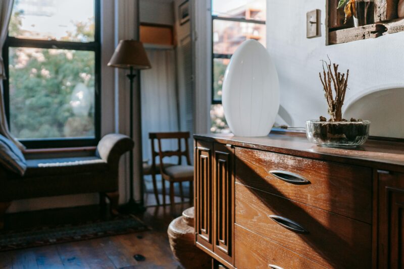 Sunlit vintage living room with wooden furniture, creating a cozy and serene atmosphere.