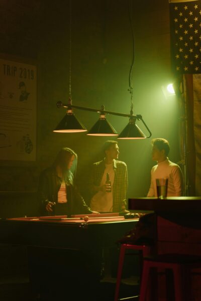 Group of friends enjoying a casual night indoors at a bar playing pool.
