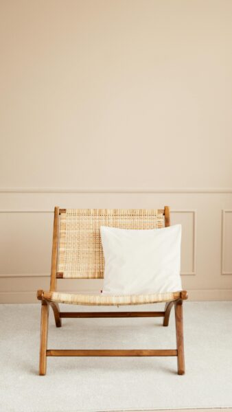 Cozy wooden chair with cushion in a modern minimalist room, perfect for relaxation.
