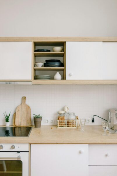 Modern minimalist kitchen with open shelving, neutral tones, wooden accents, and stylish decor.