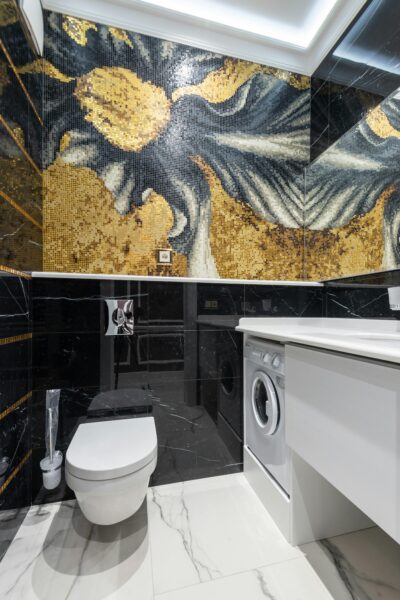 Elegant modern bathroom featuring mosaic art and integrated laundry machine.