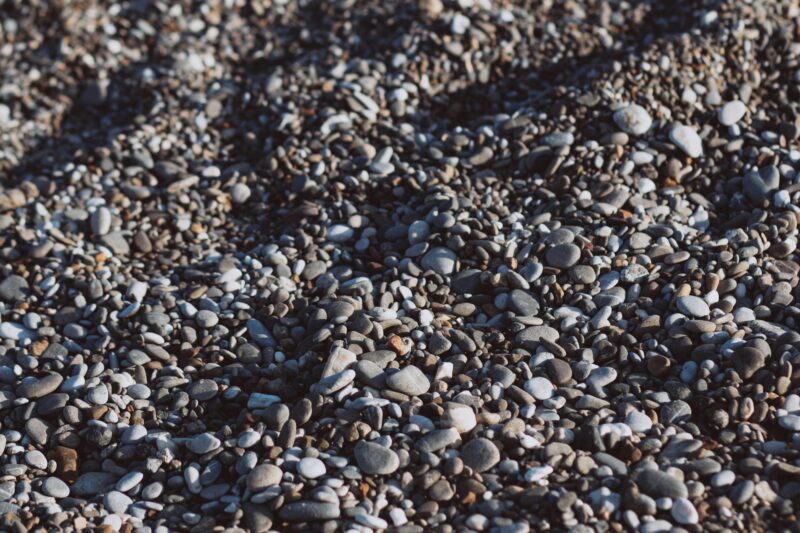 Close-up view of diverse pebbles and stones creating a textured rocky surface. Ideal for natural backgrounds.