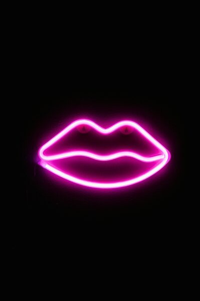 Vibrant neon pink lips decoration against a dark background, perfect for artistic spaces.