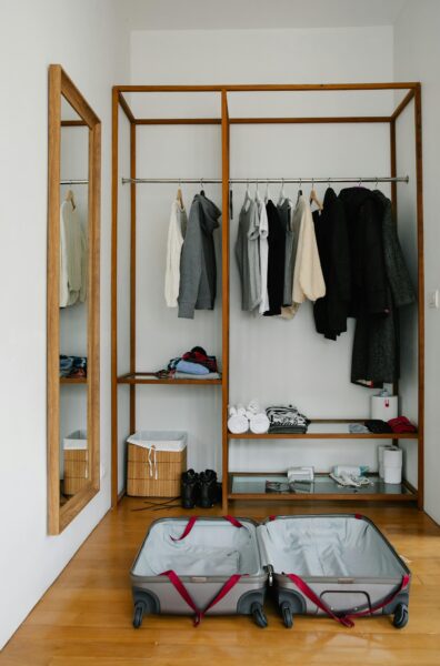 A minimal wardrobe with an open suitcase ready for packing, perfect for travel preparation visuals.