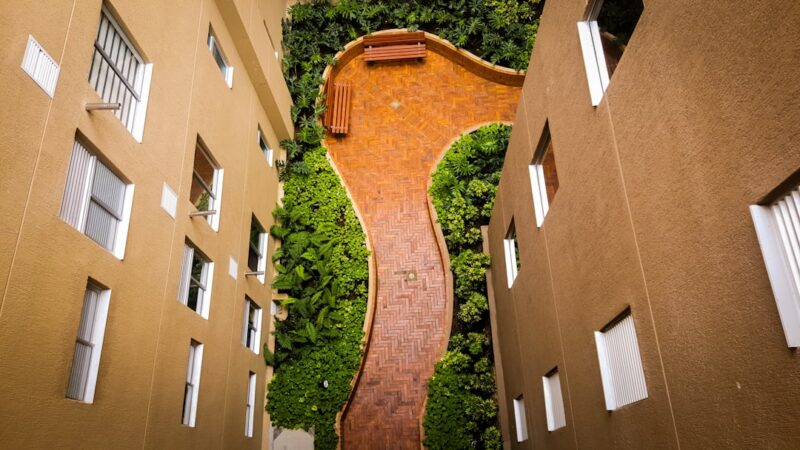 Tiled pathway between small buildings in a courtyard.
