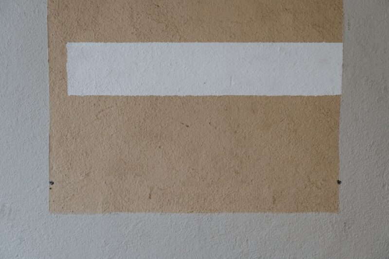 A white and brown painting on a wall