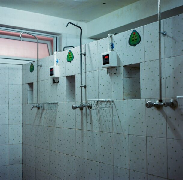 White and gray 3-person shower stall.