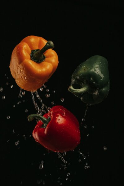 Three assorted-color bell peppers in a container.