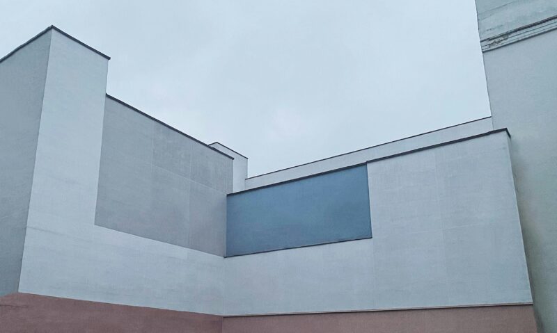 Blue and red concrete building under blue sky during daytime