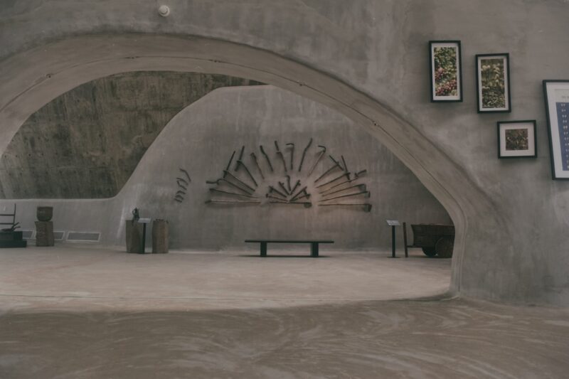 Gray concrete building with brown wooden bench