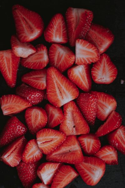 Sliced strawberries on black surface