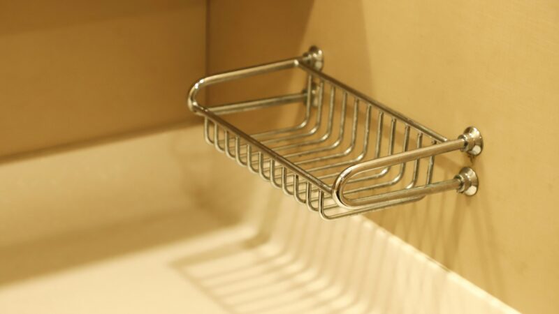 Stainless steel rack on white wall.