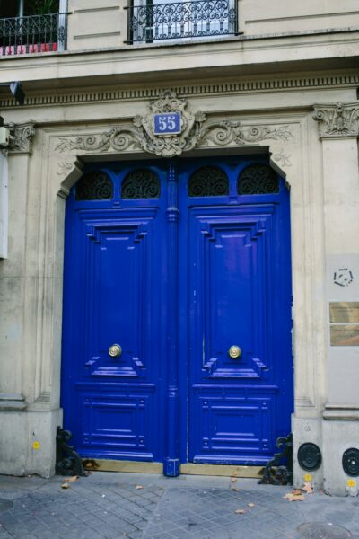 blue wooden door on white concrete building
