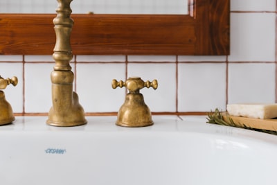 Brass faucet on white ceramic sink