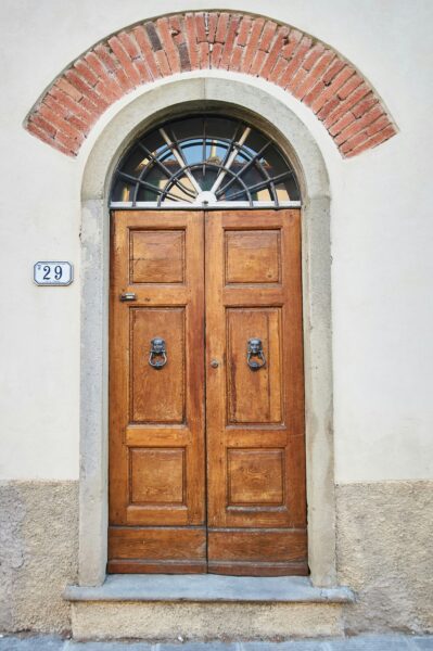brown wooden door on white concrete wall
