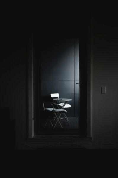 Black and white chair beside white wall.