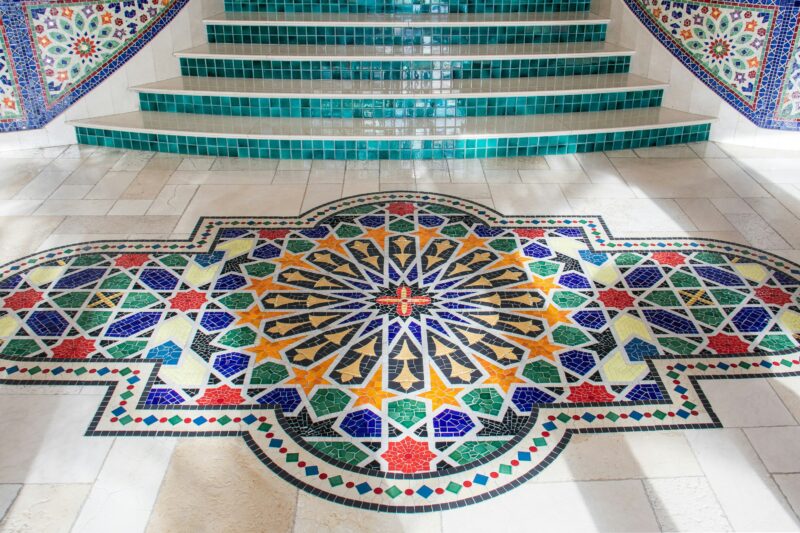 Ornately coloured, tiled steps, leading down to a colourful floor mosaic.