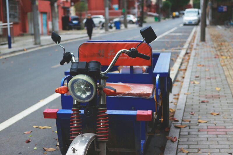 Red and blue motorcycle on road during daytime