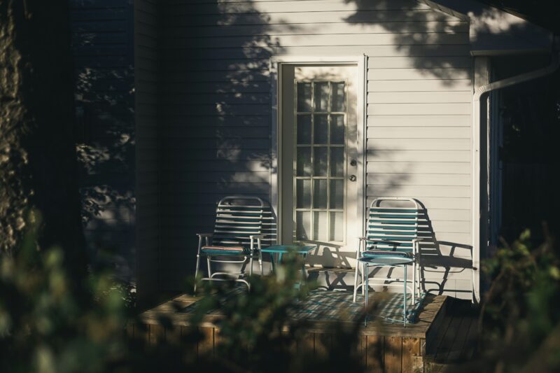 Black and white wooden armchair beside white wooden house