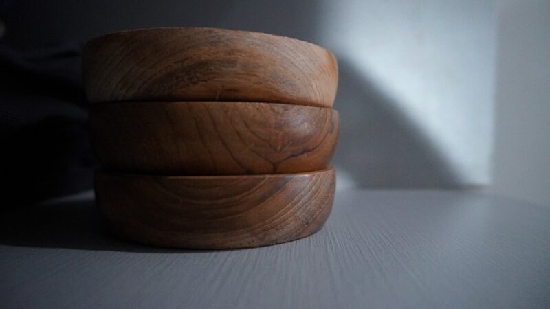 Brown wooden round ornament on a white table.