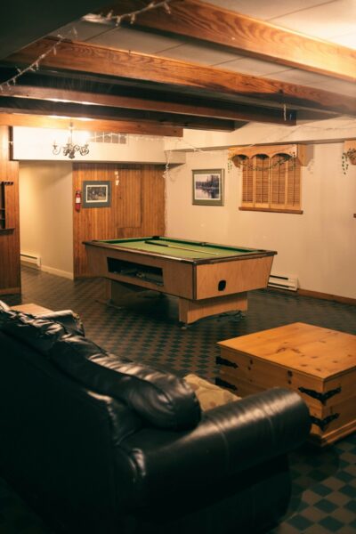 A living room with a pool table and a couch.