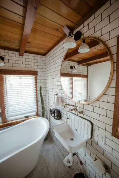 A white bath tub sitting under a bathroom mirror