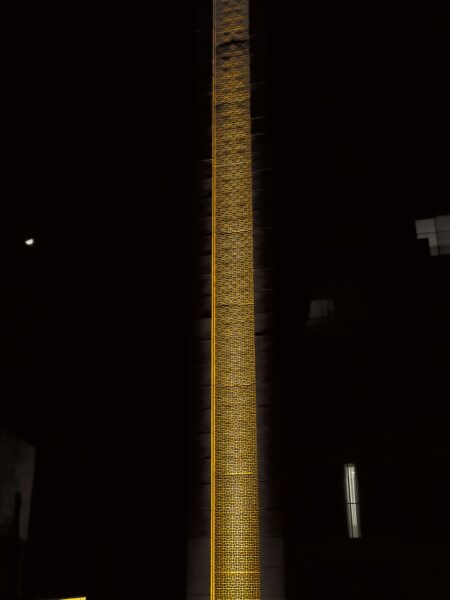 A tall clock tower lit up at night