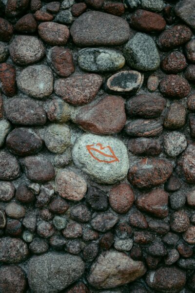 A rock wall with a rock with a letter S on it.