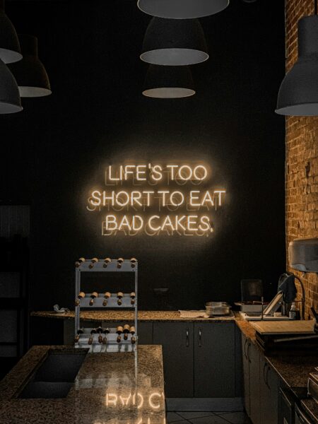 A neon sign that reads life's too short to eat bad cakes