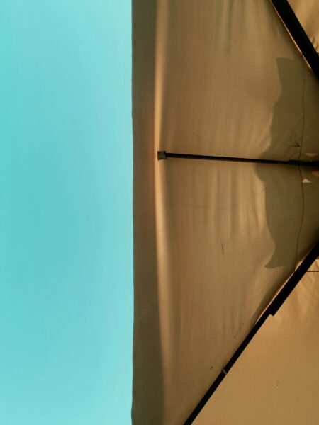 A shadow of a person standing under an umbrella