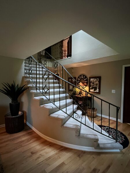A staircase in a house with a potted plant next to it.