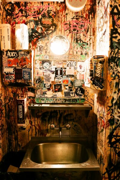 A bathroom with graffiti all over the walls.