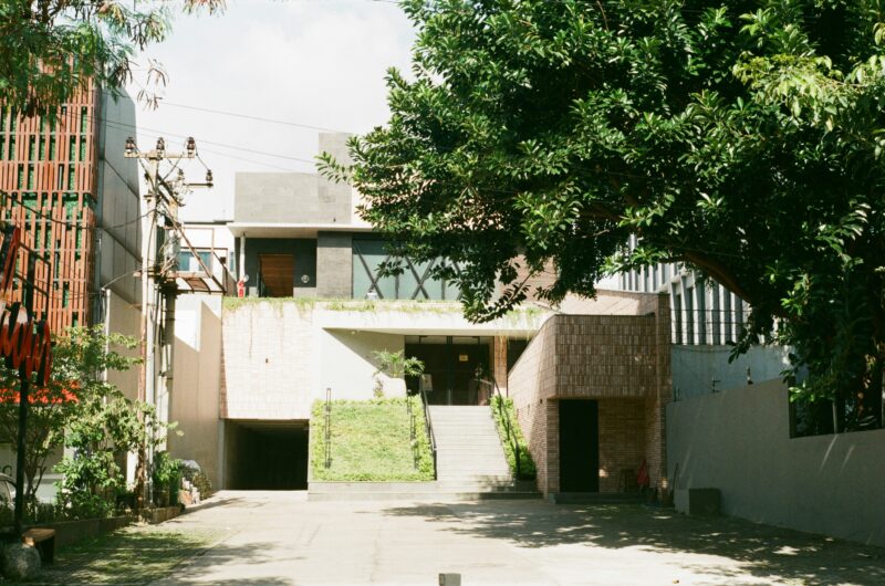 A building with a tree in front.